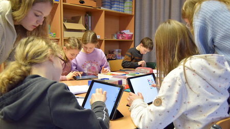 Mehrere junge Kinder arbeiten mit平板电脑。 