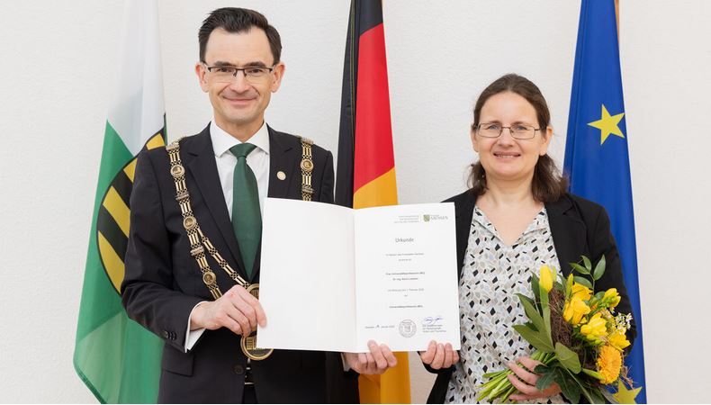 Der Rektor der TU Chemnitz Prof. Dr. Gerd Strohmeier und Prof. Dr. Karin Leistner stehen nebeneinander und halten die Ernennungsurkunde