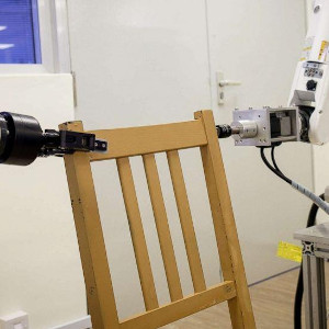 Image showing two industrial robots working together on a chair.