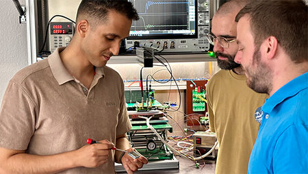 Drei Männer arbeiten in einem Elektrolabor.