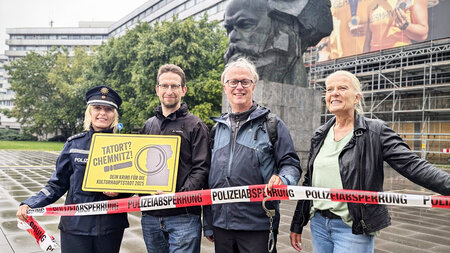 Mehrere Personen stzehen nebeneinander und halten ein Absperrband in den Hnden. 