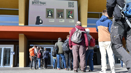 Viele Personen stehen in einer Schlange vor einem Gebäude