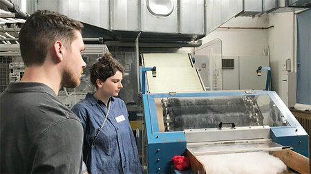 Ein Mann und eine Frau stehen neben einer technischen Anlage.