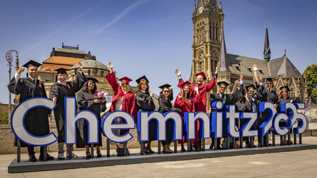 Mehrere Personen werfen Hüte in die Höhe.