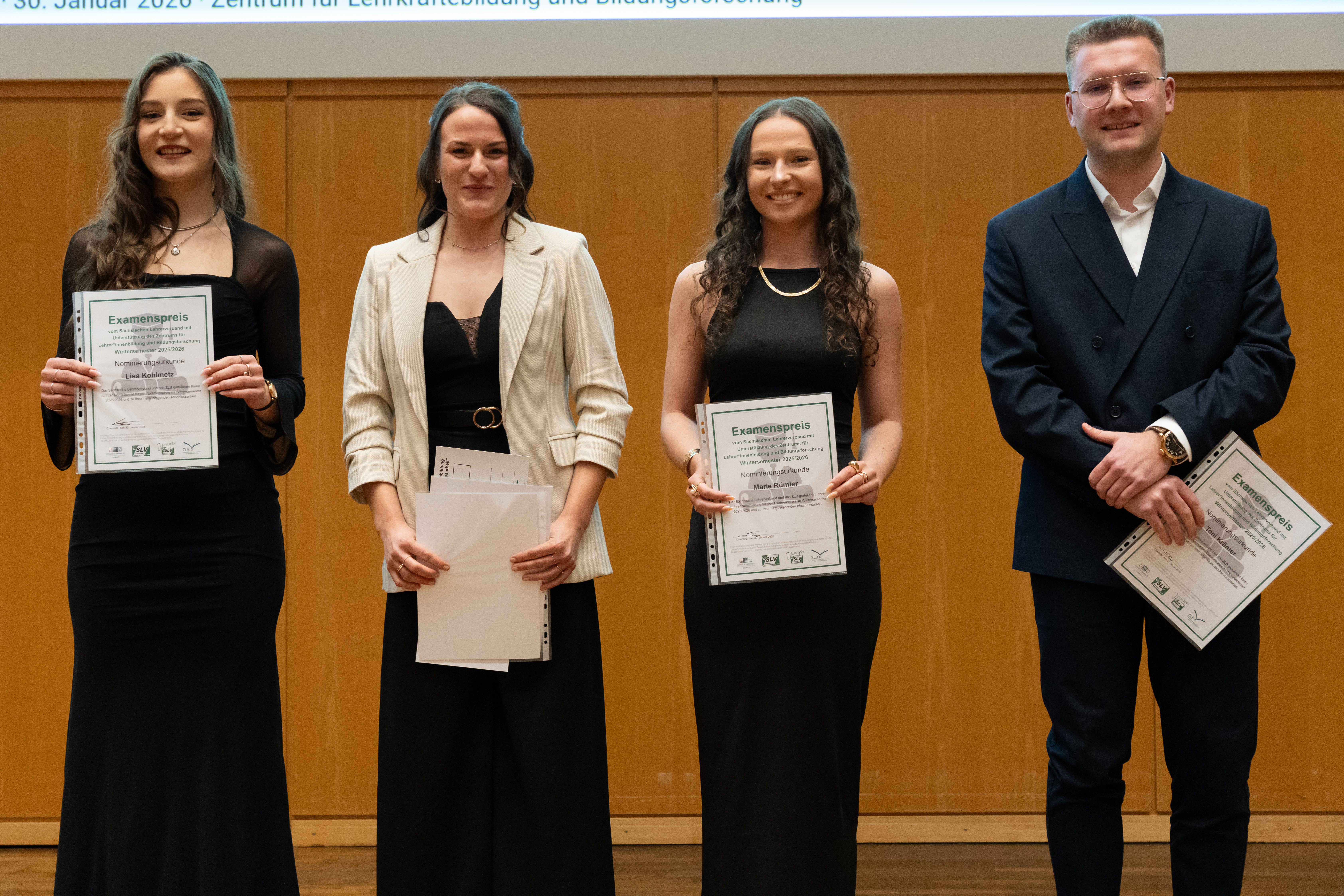 Lehramtsstudenten mit Zeugnis und Blume