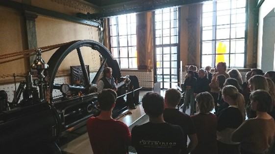 Studenten vor einer Dampfmaschine